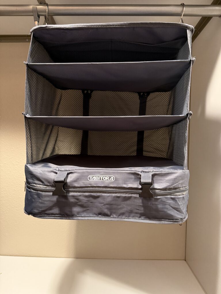 Hanging packing cube with multiple compartments, ideal for organizing clothes and accessories during travel. Makes unpacking fast and easy!